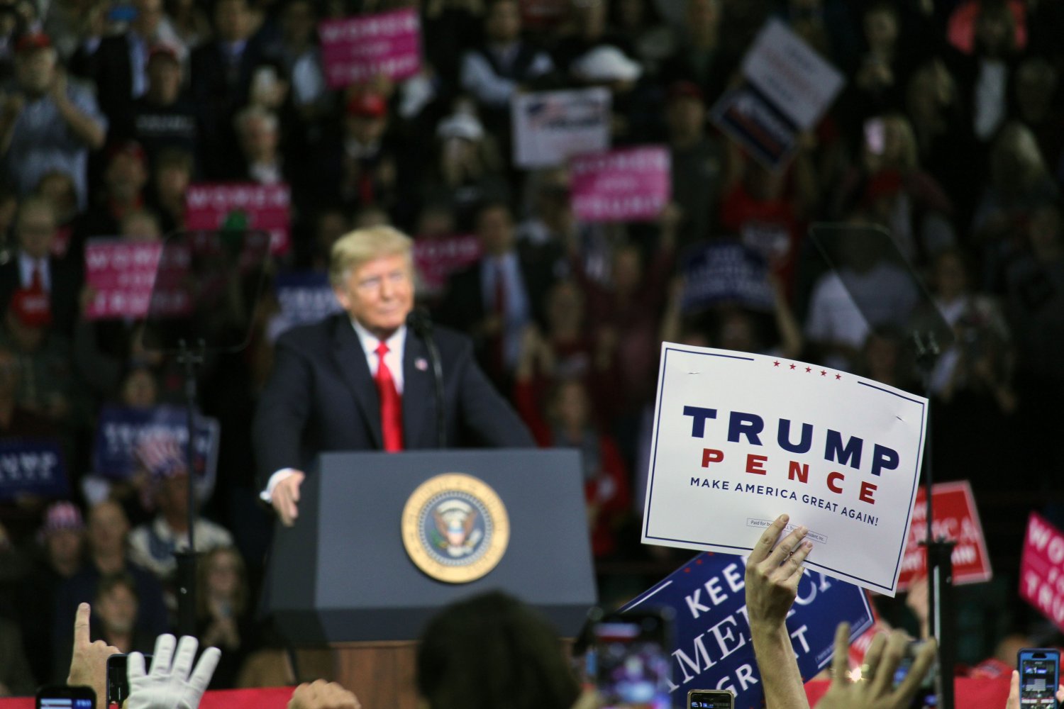 A member of the crowd hold up a sign as President Donald Trump speaks. Trump spoke in Topeka, Kansas on Oct. 6 to show support for Secretary of State of Kansas Kris Kobach, who is running for governer, and Steve Watkins, who is running for Senate, while also promoting his 2020 campaign.