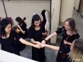 Sophomore Amy Joo, junior Audrey Parish, and seniors Liz Efken and Grace Hart fist bump after successfully practicing a viola part in String Quartet No. 8. They and the res of Chamber used their time in the dressing room to quickly rehearse small parts before they went on stage for thier KMEA performance. Photo by Sophia Comas