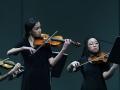 Sophomores Jenna Keeley and Richelle Collado play the final movement in String Quartet No. 8 during the Kansas Music Educators Association conference last Friday. They and the rest of Chamber Orchestra played without the direction of Nate McClendon, who sat in the audience as they played the piece. Photo by Sophia Comas