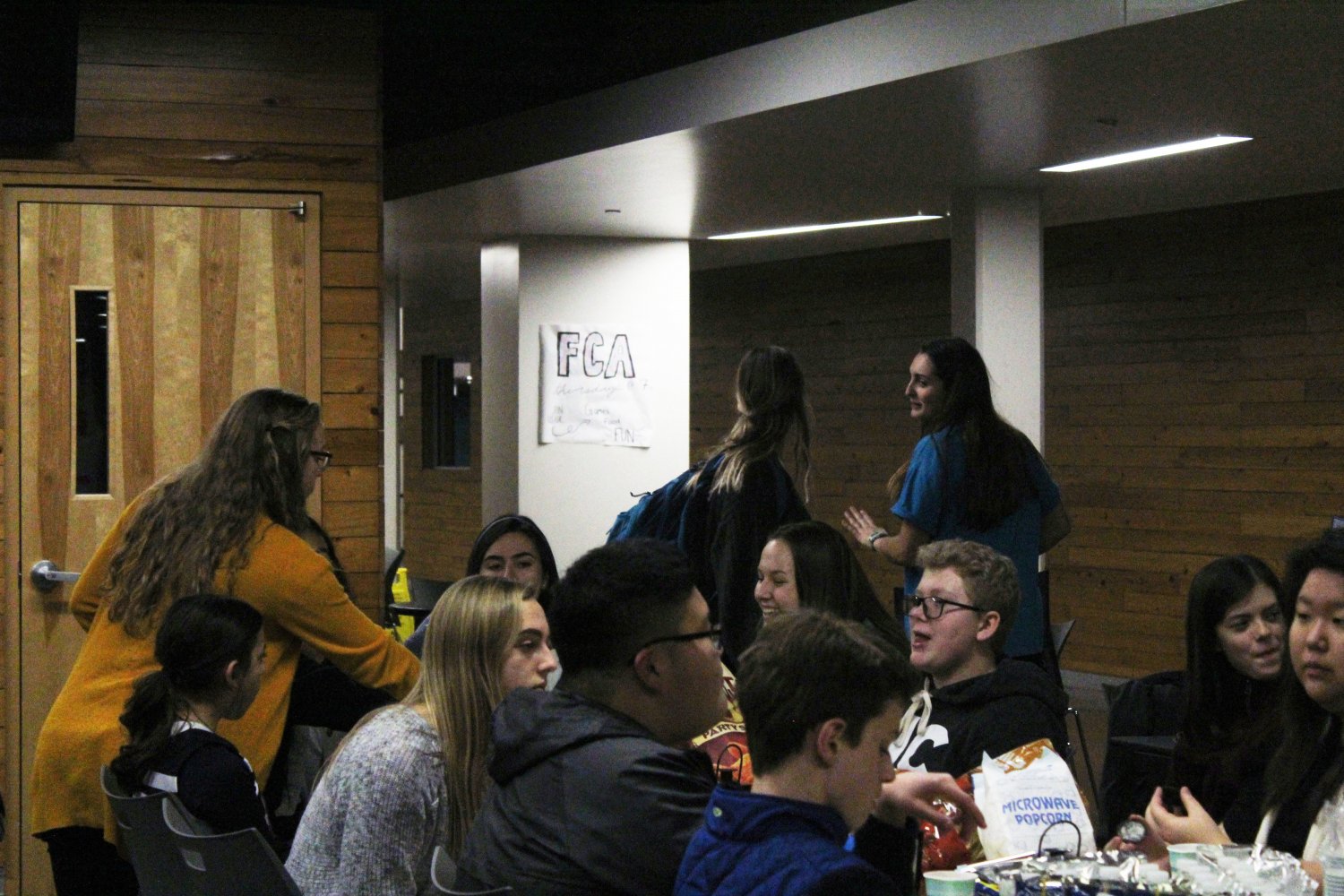 Students laugh together as they enjoy their food at the StuCo club feast. Senior Macy Hendricks reaches for more snacks as she talks to other club members.
Photo by Kyla Barnett