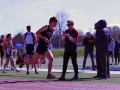 Helping Hand. Juniors Aaron Hoff cheers on his teammate Brady Foltz as he's on his last lap of the 4x4. The meet took place at Bishop Stadium on Apr. 12. Their team came in second place at the meet. Photo by Mason Alberto.