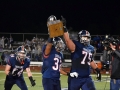 Senior BJ Young holds up the silver trophy and teammate senior Sam Shields raises his arm in victory. Manhattan High School and Junction City competed for the trophy, rivalry award and bragging rights on Oct. 11 at Bishop Stadium. The game was neck-and-neck going into the fourth quarter but MHS pulled ahead 29-28 after making the extra point in the final moments of the game. Photo by Hailey Eilert