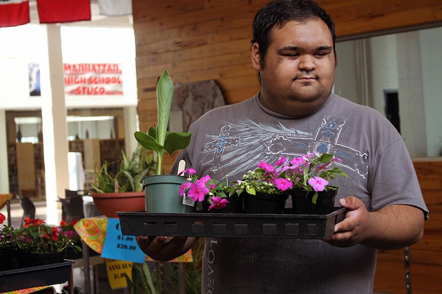 Senior Michael Jorden waits to escort the school nusre Robyn Smith back to her class room with her plant that were prushaed at the plant sale, Pots of Petals, put on by Greenhouse. Greehouse is a class designed for students within the special eduaction department to be able to have a hands on curriculum for their science class. I like it [the Greenhouse] because you get one with nature. [You] get close to pretty much what people are surroding themselves with and a place where you can be yourself. said Jorden