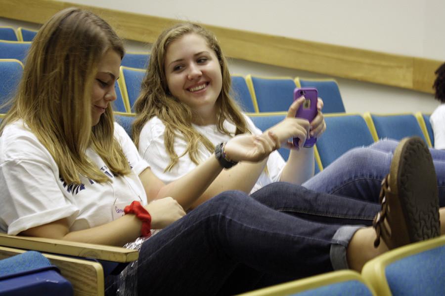 Juniors Grace Gallagher and Lauren Davis socialize in the Little Theater before the Discussion Group Leaders Meeting. In the meeting, the topics for small groups were discussed.