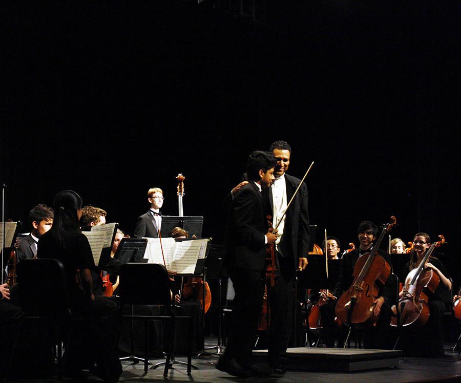 Senior Arnav Das is congratulated after his solo by orchestra director Nate McClendon. Solos are rare and hard to come by in orchestra, so Dass solo was a major event at the concert that night.