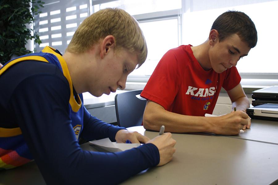 Senior Zach Francis and a classmate draw on the logos for their companys planes.