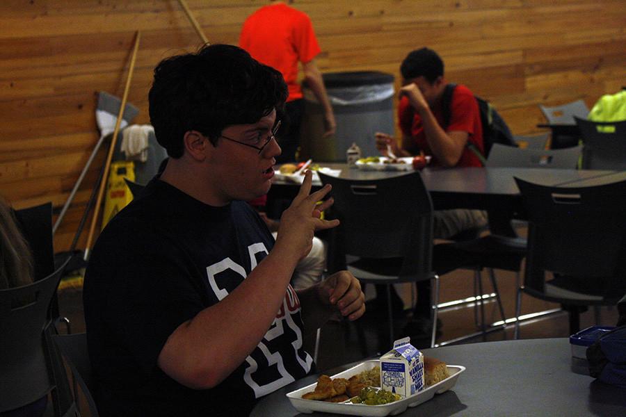 Junior Cody Bell talks to his friends while eating lunch. Bell learned sign so he could intrepret for the special needs kids.