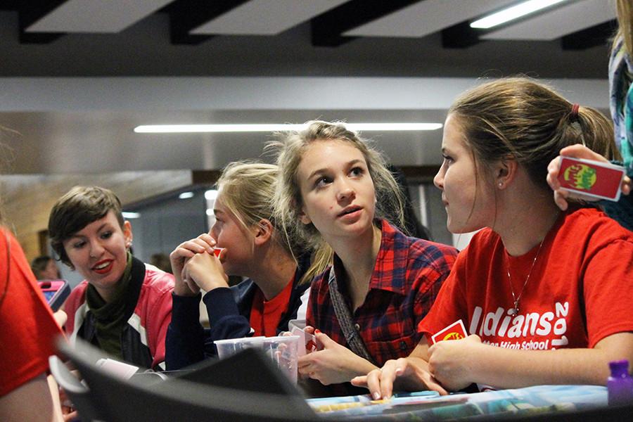 Sophomores Neeley Joyce, Ella Bahr, Joy Gruenbacher and junior Elora Root compete against each other in a game of Apples to Apples with other students at the 2015 Club Feast.