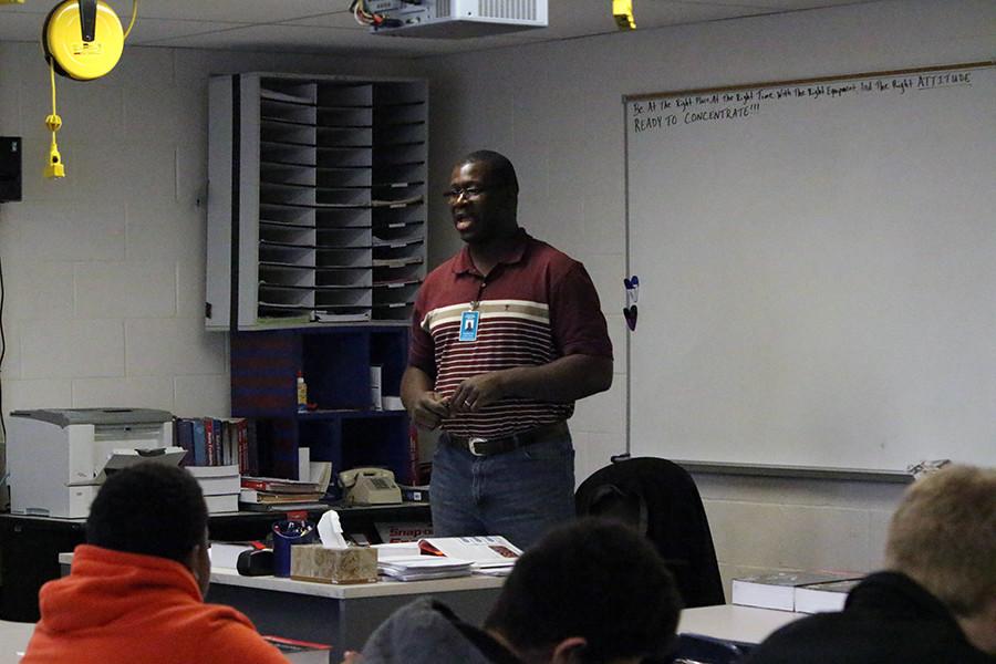 New teacher, Chris Collins, reviews a worksheet with his 5th hour Introduction to Automotives. Collins settles into teaching, after being recently hired by the school district.