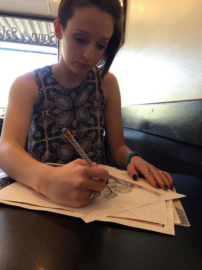 Junior Camille Fellers works on a sketch Saturday, May 8 at a coffee shop.