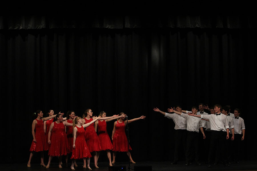 The boys and girls of Pops Choir separate and reach out towards each other during their Grease performance.