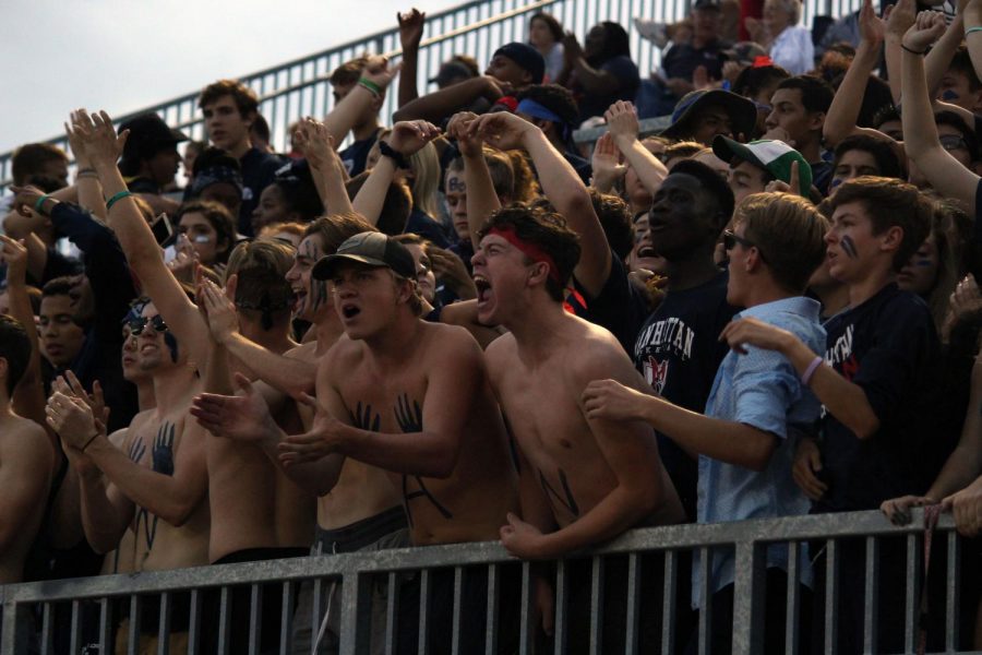 Seniors Jonah Evarts and Adam Fischer yell during kick-off as Manhattan returns the ball at the Junction City varsity football game.