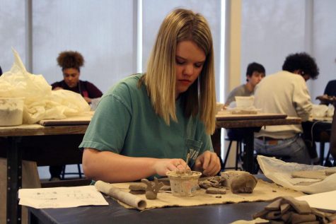 Senior Riley Taylor pats down the clay with water to keep it moist. Students in Sara Rempels Ceramics care allowed creative freedom to make whatever they want as the school year comes closer to an end. Photo by Dylan Thomas