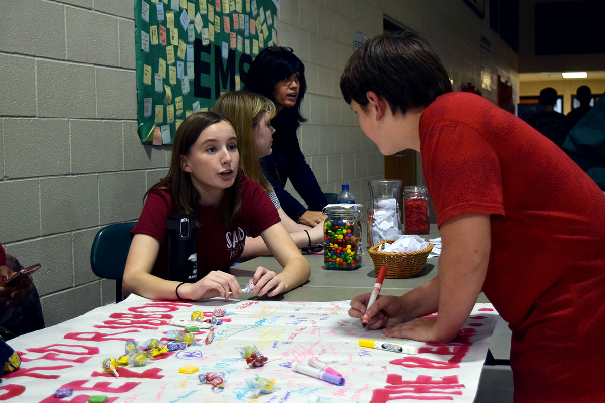 Senior Cami Wells talks to an Eisenhower Middle School student about Red Ribbon Week. SADD members travelled to EMS on Oct. 26 to motivate students to be drug free.