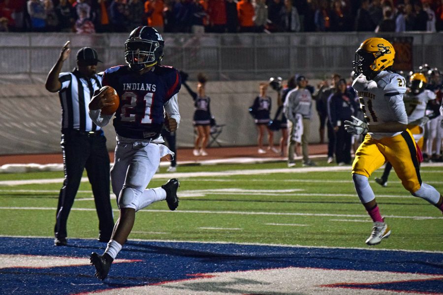 Senior Kevontae McDonald runs the balls into the endzone during the Oct. 26 Manhattan High School Varsity football game. The Indains defeated Wichita Southeast High School 73-20, adding another win to their current season. 