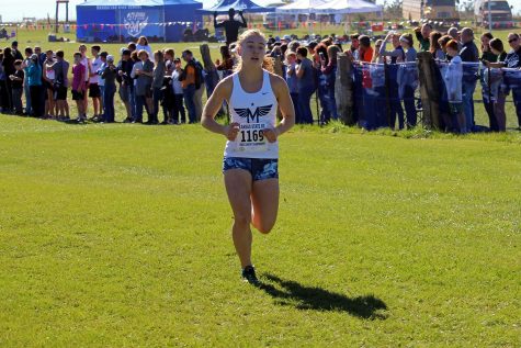 Senior Clara Mayfield sprints to the finish line at the Cross Country State competition. Both the Girls and Boys Manhattan High School Varsity Cross Country teams competed on Oct. 27, at the meet Mayfield placed third. 
