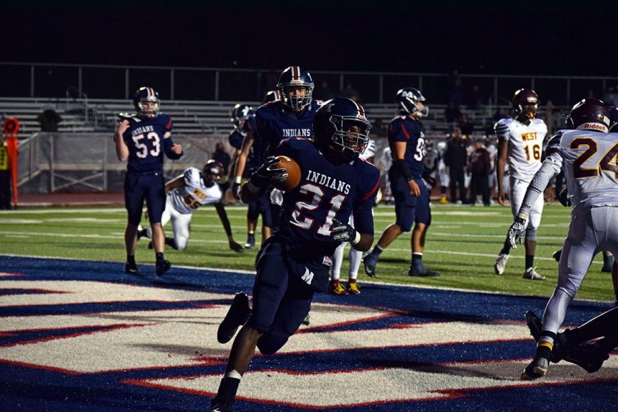 Senior Kevontae McDonald runs the ball in for the extra point at the Nov. 2 Manhattan High School Varsity football game. The Indians played against Wichita Southwest beating them 36-25. 