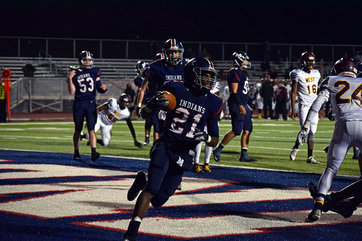 Senior Kevontae McDonald runs the ball in for the extra point at the Nov. 2 Manhattan High School Varsity football game. The Indians played against Wichita Southwest beating them 36-25.