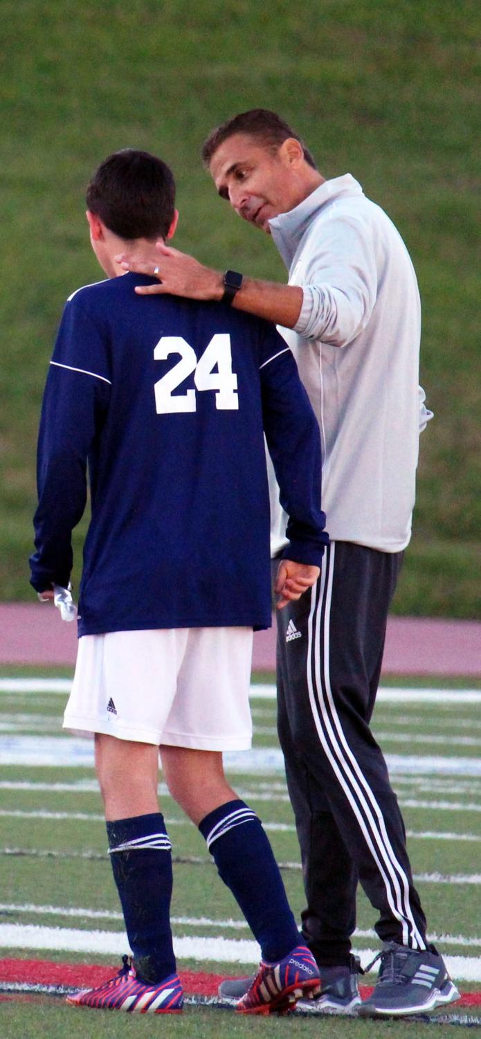Head coach Frank Alonso walks along the field with senior Jack Easton during the Varsity boys Senior night soccer game.