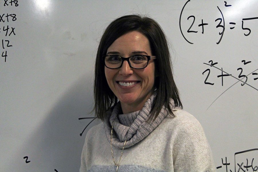 Teacher Dedra Braxmeyer smiles while standing infront of the whiteboard in her classroom. Braxmeyer is a math teach at Manhattan High School who was recognized with the Teacher of the Year award. 