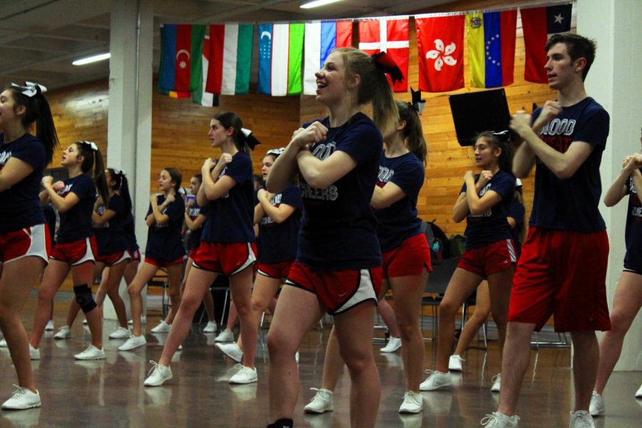 Sophomore Carrie Cave practices basketball cheers and moves with other members of the squad during the Manhattan High cheer practice after school on Dec. 3.