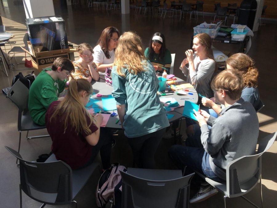 Members of the Hugs for Humanity committee paint pictures in The Commons.