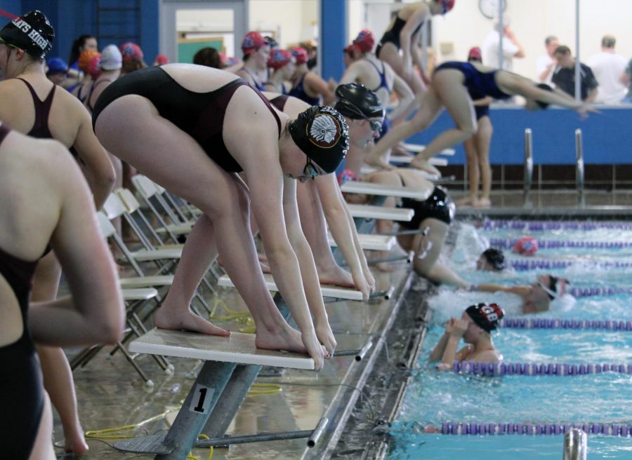 Girls+Swim+and+Dive+get+ready+to+pounce+into+the+water+to+make+a+splash.+They+competed+against+Hays%2C+Junction+City%2C+and+Great+Bend+on+April+15.