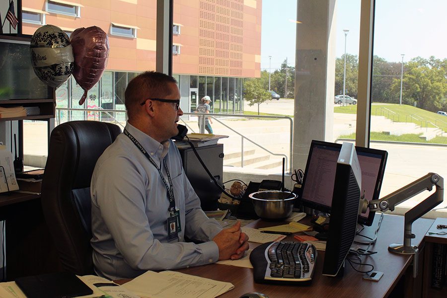 Dorst works on his computer while on a phone call in his new office. While he enjoys the new location for now, he also misses his old office, which allowed him to see student interaction that gives MHS what he calls its "pulse."