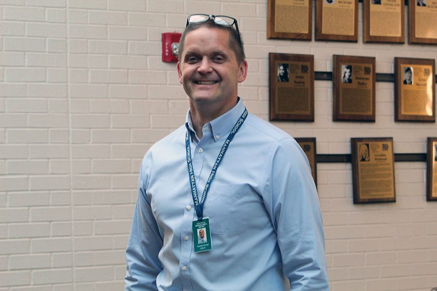 Principal Michael Dorst stands in his favorite spot within Manhattan Highs West Campus located along The Alumni Wall of Fame and the front doors. The spot, which he calls The Heart of MHS, allows him to see every part of the building as well as the one place where every person must pass in order to walk through the school.