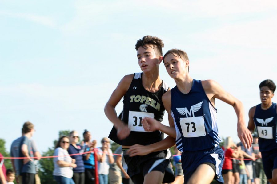 Freshman Zachery Goscha fights for a time win against a Topeka runner. Goscha placed 22nd with a time of 20:10.2, -- just one tenth of a second away from 21st -- having ran a 4K at the Warner Park meet on September 7. The boys Junior Varsity team placed first with a score of 19, Garder-Edgerton second with 68.