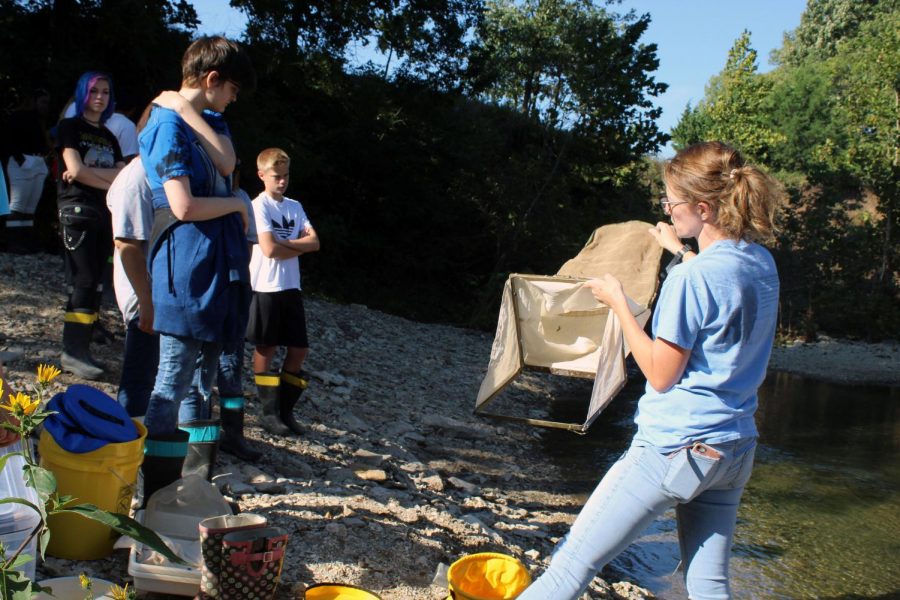 Hallie Hatfield shows students what to use to catch the vertebrates in the creek.