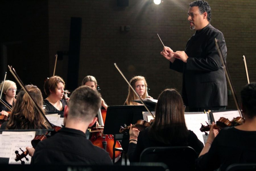 Director Nate McClendon stands above the freshman orchestra at hey begin their performance. The group performed with both Symphonic and Chamber Orchestra to commemorate their performance season.