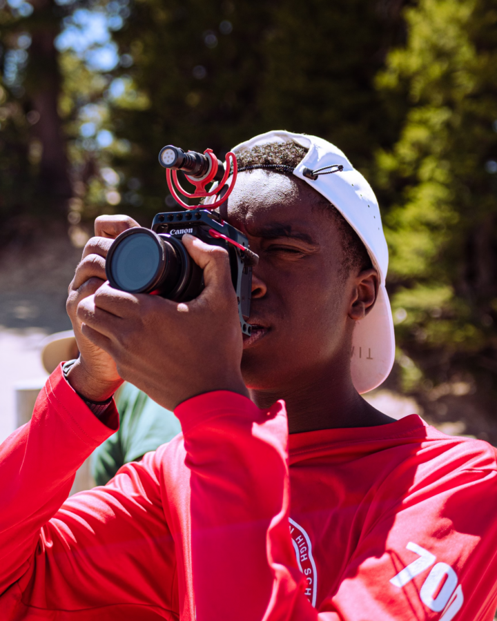 Adjusting his camera for the perfect shot, senior Max Bowyer gazes at the world through a lens. About three years ago, Bowyer started a YouTube channel and since then has participated in a number of video production opportunities to further his skills. Courtesy Photo