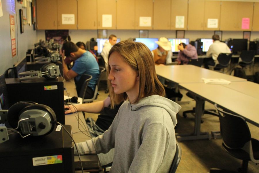 Senior Halle Gaul works on her graphic design for the Adjudicator Club at Manhattan High. Photo by Madelyn Cook