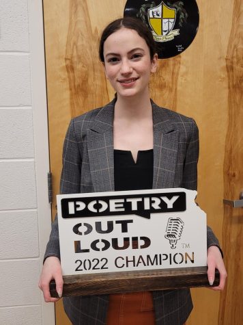 Junior Allie Cloyd proudly presents her Poetry Out Loud Champion plaque.