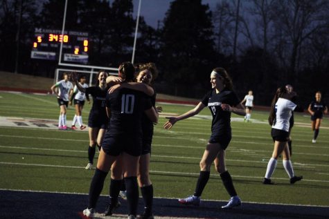 Freshman Jada Dibbini hugs sophomore Emery Rullifson in celebration of a 5-0 lead over Junction City.