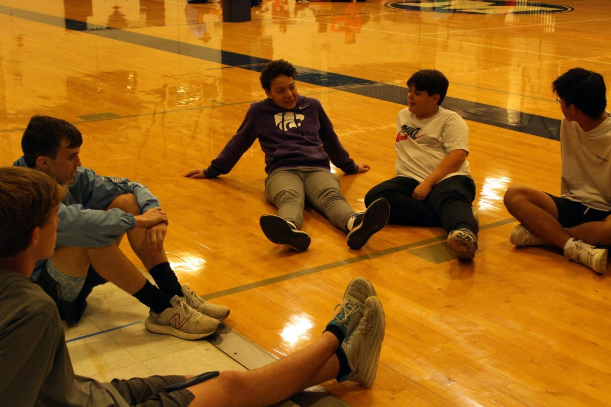 Deep talk. Senior Lucas Holdren (far left) leads a conversation about this weeks Bible passage with a small group of freshmen and sophomores.