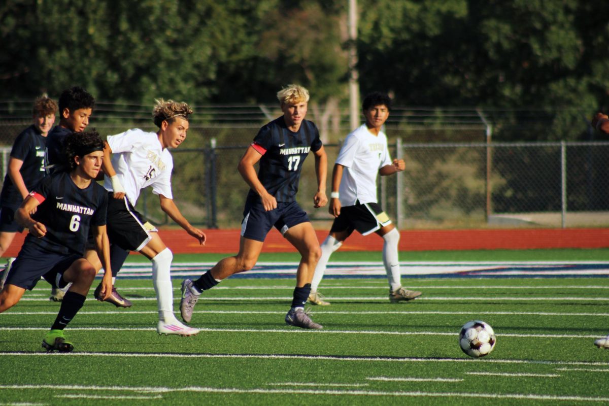 All in. Colby Taylor of grade 11 and Ian Wassom of grade 12, on opposite sides of their opponent, work together to make sure either of them get to the ball first.