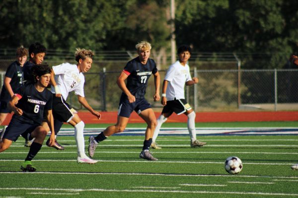 All in. Colby Taylor of grade 11 and Ian Wassom of grade 12, on opposite sides of their opponent, work together to make sure either of them get to the ball first.