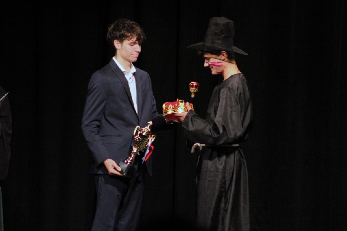 Congeulations! Patric Huser acsepting the aword to be cowned Mr MHS. the geuges were vary impressed with his mane roles in both of the songs.