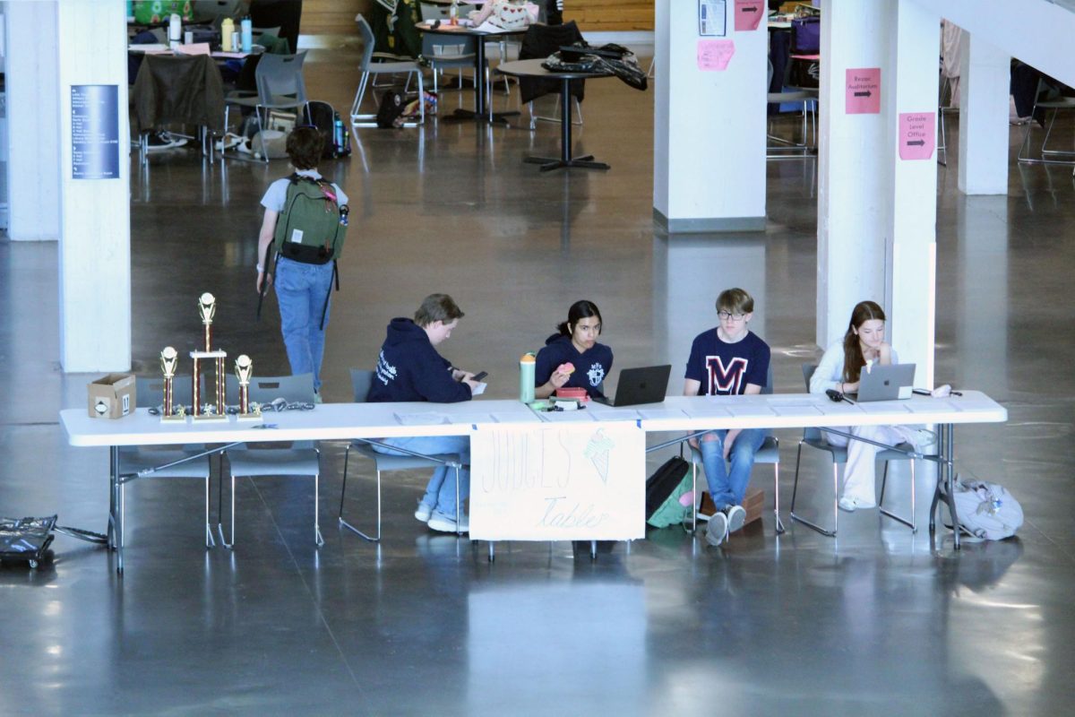 Helping. In the Commons at Manhattan High School, MHS Forensics students are running the front desk for a competition where other Forensics students from schools gather at MHS to Compete. This event ran from 8 a.m. to 2 p.m. on Feb. 28.
