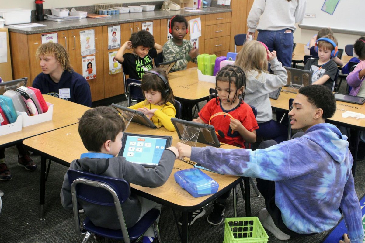 FISTBUMP Senior Sedale Fox-Clayton gives a kindergartener a well derserved fistbump after completeing a diffcult math problem. Sedale Fox-Clayton continued to help these students out by answering question and helping them work out questions on their own.