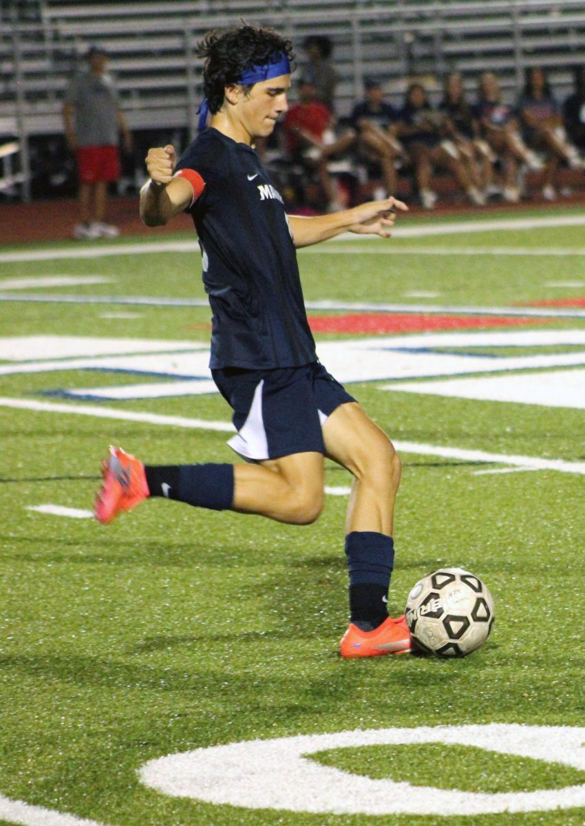 Kickin' it. Senior Ian Wassom passes the ball to his teammate, working together to score a goal.