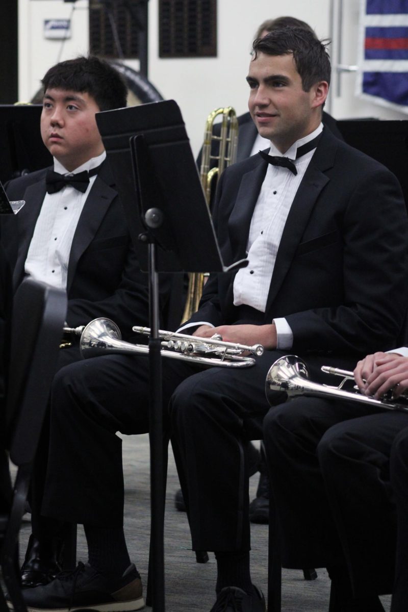 Line of Trumpets. Junior Zach McCaffrey sits at rest while the Manhattan High School Wind Ensemble Brass Ensemble prepares their chops for playing in front of a judge for the 2026 Solo & Ensemble Regionals contest. The school that hosted this event was Manhattan High School, where the high school musicians and vocalists use the classrooms to play their prepared pieces with others or alone. This contest was held on Apr. 11.