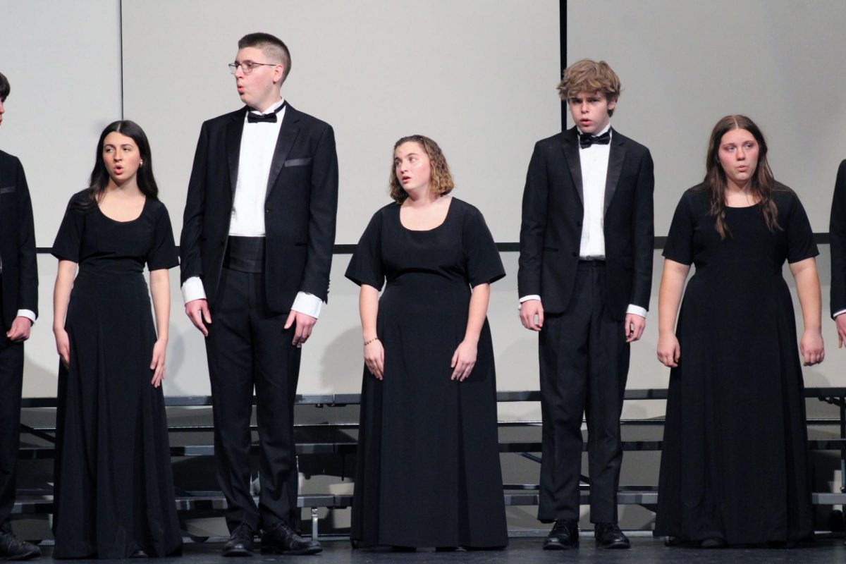 Tall then short. MHS Pops Choir students wear concert black tuxes and dresses for the regional level contest of Solo & Ensemble, where students from multiple high schools visit Manhattan High School and get to play solo pieces and ensemble pieces in front of friends, family and a judge, who will give them a rating on their musicianship and playing skills.