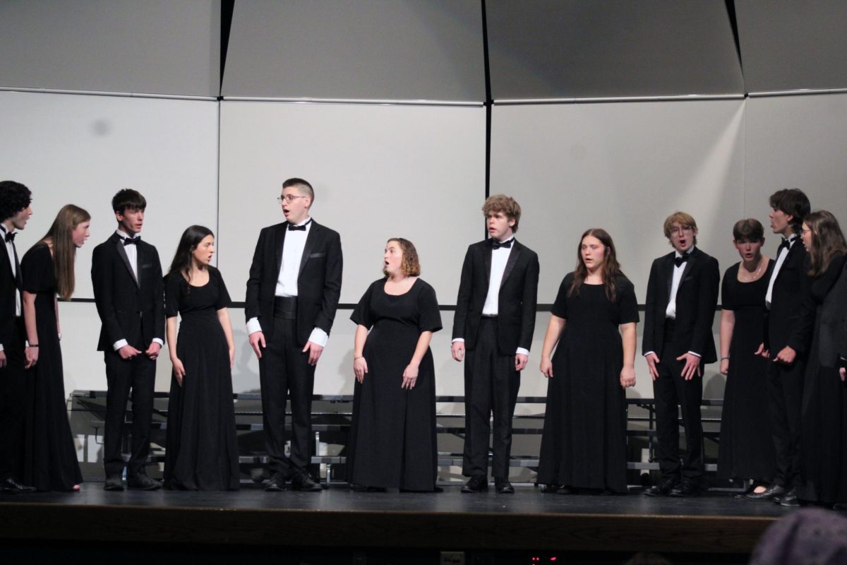 Watch and sing. The MHS Pops Choir semicircle up to sing unaccompanied, classical pieces instead of their normal pop songs for the Solo & Ensemble Regionals Contest on Apr. 11. This contest was hosted by Manhattan High School, where they used many of the classrooms and Rezac to have the musicians and vocalists get graded by a judge.