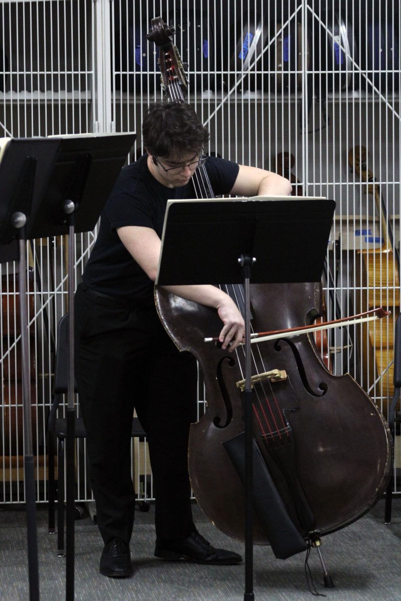 Big Bass. Junior Will Gilligan bows on his string bass, keeping the low notes present for the group of string players he is playing with at the Solo & Ensemble Regionals contest. The group was named C.l.A. or Cellos International Association for this event, which was on Apr. 11, at Manhattan High School.