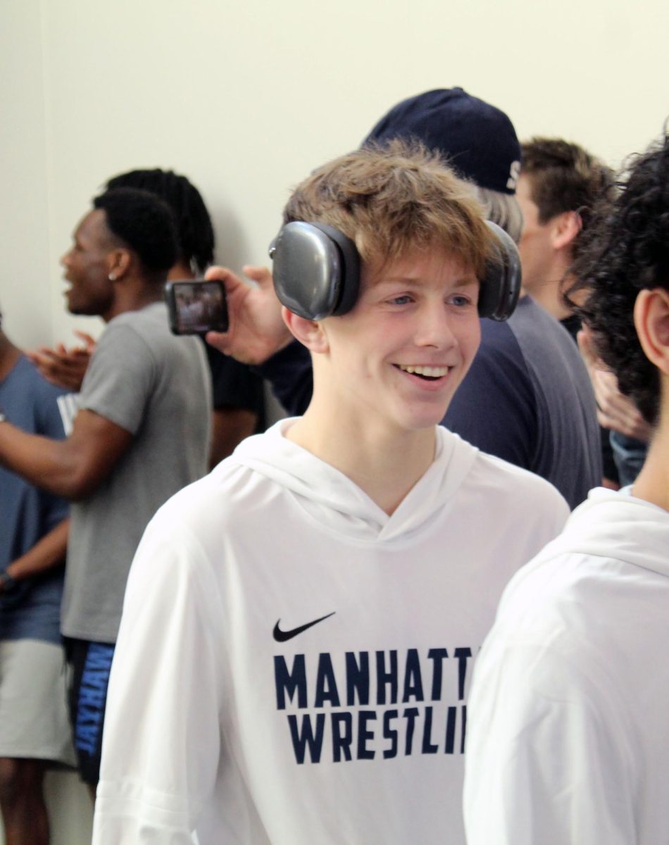 Exciited Sophomore Jack Hutchinson smiles while he walks out of Manhattan High to go to state wrestling. 