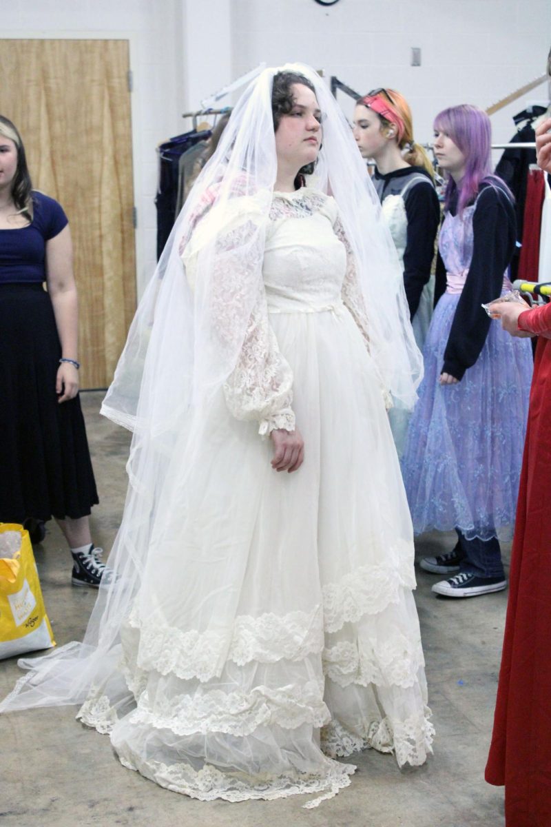 Big Day. Junior Ella Grier struts their stuff wearing a stunning wedding dress costume while running the costumes crew for the Manhattan High School spring play, Proofs. The tech day this was taken on was Apr. 26, where the actors and crew members worked on their lines and prepped the outfits for the big show.