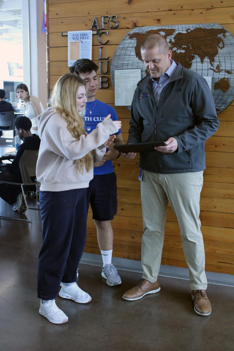 Explanations. Foreign exchange student Khadija Ahmad explains to the Manhattan High School principal what this award that he has been given is about. The award is a physical piece of appreciation from the AFS program to Mr. Dorst for having two funded exchange students stay at the school for a year. 
